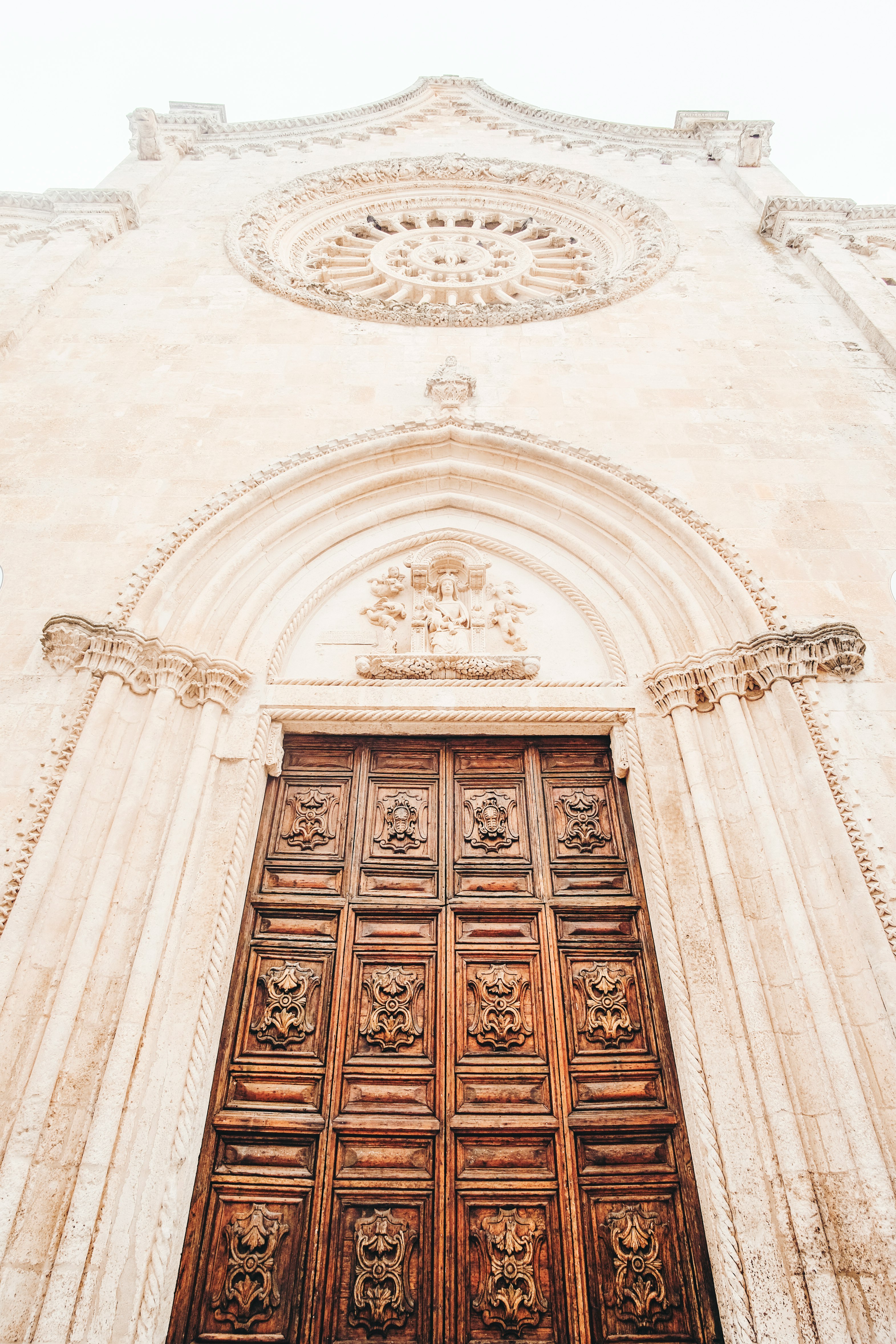 brown wooden door on white concrete building